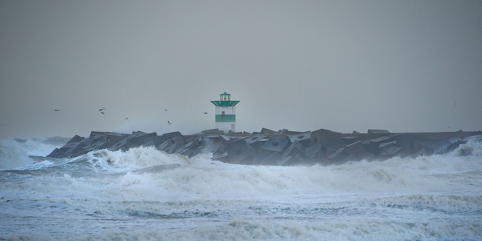 Golven beuken op het Havenhoofd van Scheveningen, tijdens een flinke storm.
