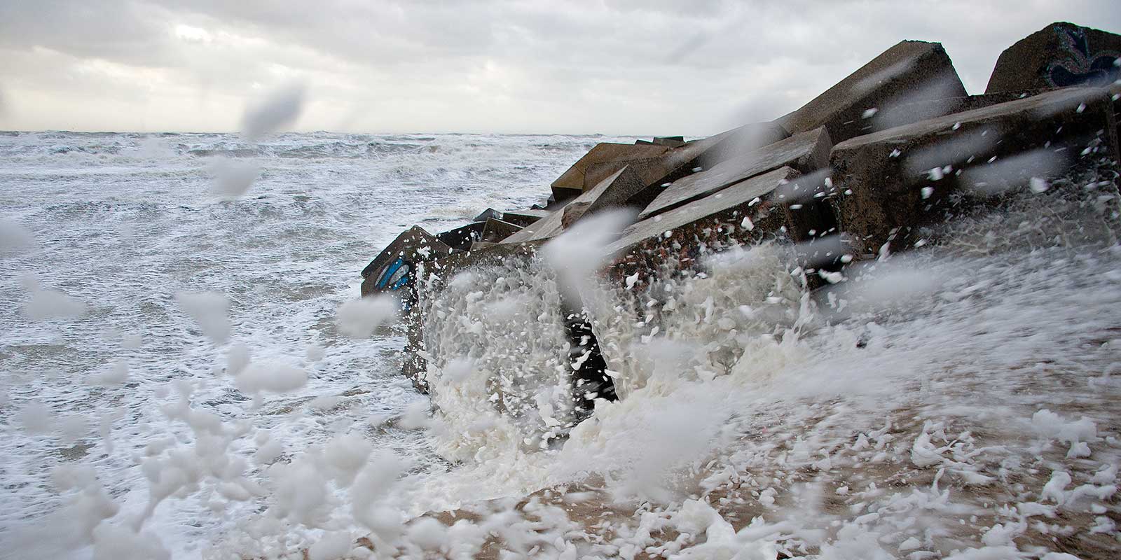 Golven beuken op het Havenhoofd van Scheveningen, tijdens een flinke storm.
